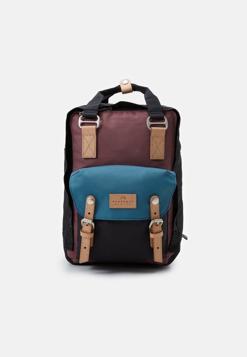 Mochila com um corpo bordô, base preta e um bolso frontal teal. Construída em tecido durável com alças de couro e ferragens metálicas.