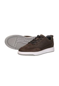 Bruine suède sneakers met een gladde textuur, voorzien van zwarte veters, een witte rubberen zool en een grijs loopvlakpatroon aan de onderkant.