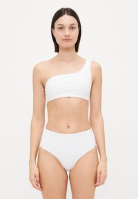White bikini set featuring a one-shoulder top and high-waisted bottoms. Smooth texture with no patterns or accents. Minimalist design.