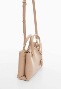 Borsa a tracolla in pelle beige con manici corti, tracolla regolabile e removibile, dettagli in metallo dorato e un design strutturato.