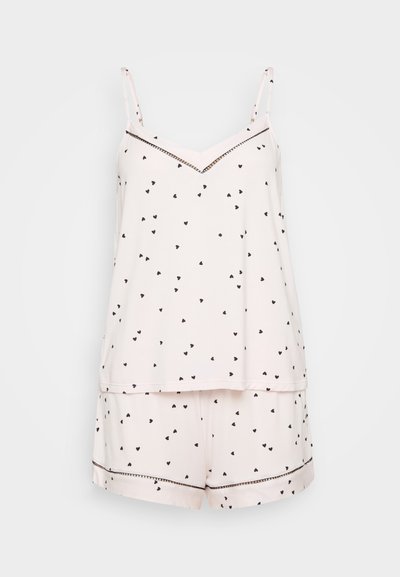 Svijetloružasti pidžama set s crnim printom srca, koji se sastoji od topa bez rukava s V-izrezom i kratkih hlača s kontrastnim obrubom oko ruba.