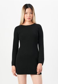 Svart langermet strikket kjole med en tettsittende silhuett og rund halslinning. Glatt tekstur, midt på låret lengde, minimalisk design.