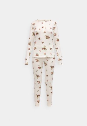 Pitkähihaiset pyjamapuku vaaleassa puuvillassa, jossa on kukkakuosi punaisilla ja vihreillä yksityiskohdilla. Sisältää napitettavan kaula-aukko ja sovittuvat housut.