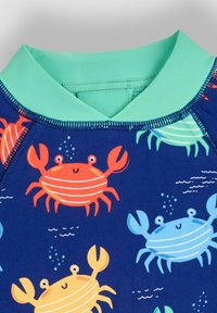 Børnesvømmet-shirt med en turkis krave, med en marineblå baggrund og farverige krabbe-mønstre i orange, blå og gul.