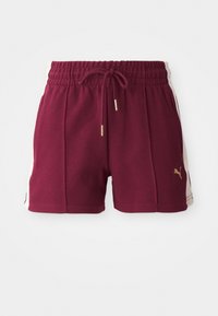 Shorts de sport bordeaux en tissu texturé, avec une taille élastique, un cordon de serrage et des panneaux latéraux crèmes comportant un détail de logo doré.