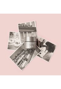 Crema potenciadora de colágeno y péptidos del Doctor Babor en un frasco cilíndrico plateado sobre un fondo rosa, rodeada de fotografías en blanco y negro.