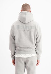 Grijze pullover hoodie van een katoenmix, met een grote capuchon, ribgebreide manchetten en zoom, en met het "Blckbnns" logo in een subtiele print op de achterkant.