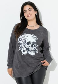 Camiseta de manga larga en gris oscuro con un gran gráfico de calavera adornado con acentos florales. Tejido suave con un corte relajado.