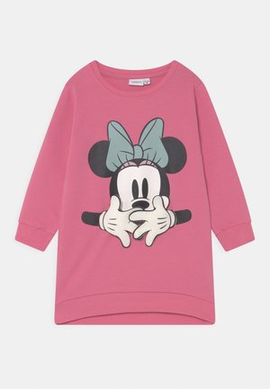 Haut pour enfants à manches longues rose avec un grand visage de Minnie Mouse portant un nœud bleu et des gants blancs couvrant sa bouche.