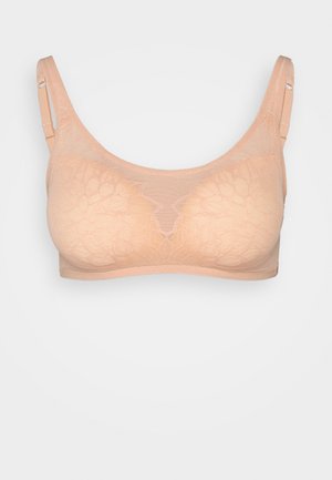 Beżowy biustonosz typu bralette z koronką o miękkim, teksturowanym wykończeniu. Posiada regulowane ramiączka i bezszwowy design bez widocznych elementów metalowych.
