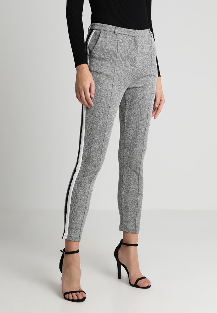 Kalhoty s šedým houndstooth vzorem a bílými bočními pruhy. Přizpůsobený střih, střední pas, přední kapsy a hladká textura.