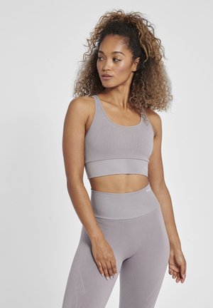 Lichtgrijze sportbeha met ribbelstructuur en een brede band, gecombineerd met bijpassende high-waisted leggings met subtiele ontwerpaccenten.