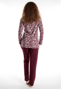 Maroon pajama set featuring a floral-patterned top with long sleeves and a relaxed fit, paired with matching straight-leg pants.