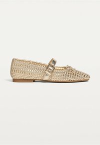 Chaussure plate tissée de ton or avec un bout pointu, une bride Mary Jane munie d'une boucle, et un petit nœud décoratif sur le dessus.