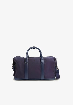 Bolsa de deporte de tela azul oscuro con asas de cuero, detalles en cuero y una correa de hombro desmontable sobre un fondo blanco.