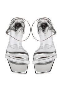 Sandali con tacco alto in metallo argentato, con punta aperta, forma quadrata, sottile cinturino alla caviglia e fascia frontale piatta. Materiale riflettente e testurizzato.