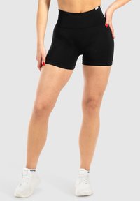 Pantaloni corti neri a vita alta realizzati in un tessuto elasticizzato, dotati di una vita a coste e una texture liscia, progettati per offrire comfort e flessibilità.