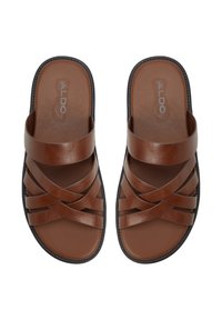 Bruine leren slidesandalen met een kruissluiting ontwerp, een gestructureerde voetbed en een zwarte zool. Merklogo zichtbaar op de binnenzool.