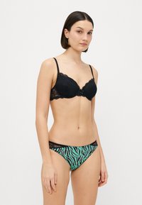 Black lace bra with padded cups and adjustable straps paired with mint green and black striped lace trim bikini briefs.