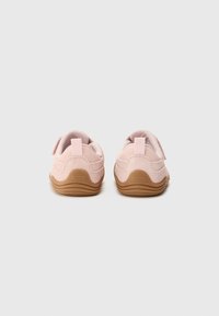 Chaussures en daim rose avec un design arrondi, dotées d'une semelle texturée et d'une doublure en tissu doux. Comprend une sangle Velcro pour un maintien sûr.