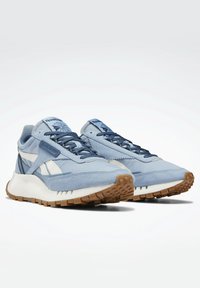 Ljusblå sneakers i mocka och mesh med vita accenter. Har en tjock vit mellansula och en brun gummisula med strukturerat grepp.