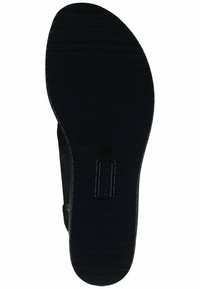 Black shoe sole with a textured matte finish, featuring horizontal grooves for grip and a rounded shape. Design includes branding detail.
