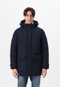 Parka blu navy imbottito con cappuccio regolabile, due grandi tasche anteriori e chiusura con zip. Realizzato in tessuti durevoli.