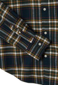 Camicia con bottoni davanti caratterizzata da un motivo a quadri blu navy scuro con accenti bianchi, verdi e gialli. Tessuto di cotone con un design strutturato e colletto standard.