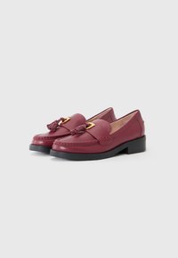 Burgundy leather loafers with a tassel and gold hardware detail, featuring a rounded toe and a low black block heel.