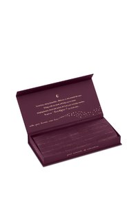 Geöffnete dunkelviolette Schachtel mit goldener Schrift, die eine zusammengefaltete Seidenschlafmaske enthält, eingewickelt in gebrandetes Seidenpapier.