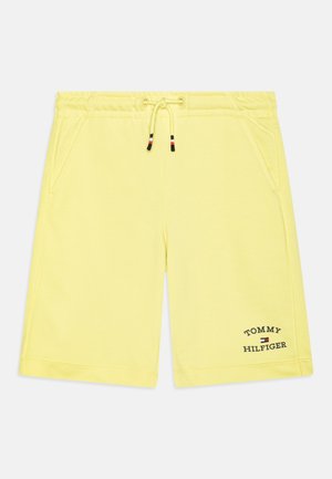 Gule bomuldsshorts med elastisk talje og snoretræk, med sidelommer og "TOMMY HILFIGER" logo nederst.