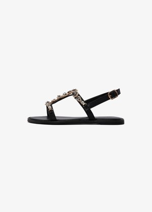 Black flat sandal with multiple straps, embellished with silver and gold rhinestones, featuring a buckle closure and smooth texture.