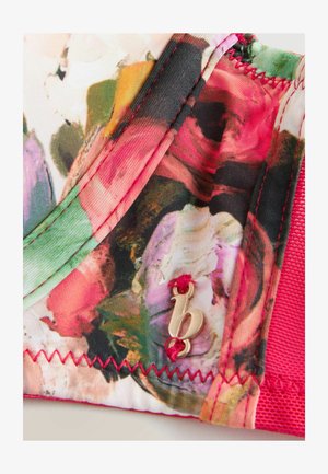 Barvna cvetlična blago z rdečimi šivi, ki vsebuje zlat brand akcent. Material je videti gladek s teksturirano rožnato podlago.