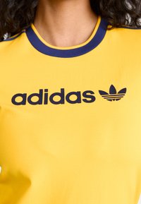 adidas Originals GRAPHIC BADGE SLIM 3-STRIPES - Triko s potiskem - crew yellow