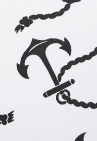 Czarny design kotwicy z akcentami liny na białym tle materiału. Charakteryzuje się wyraźnymi liniami i różnorodnymi kształtami w wzorze.