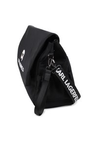 Geantă de mână neagră din nylon cu clapetă pliabilă, având un logo argintiu, o curea detașabilă cu text alb și o suprafață netedă, ușor texturată.