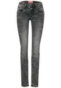 Slim-fit jeans i urtvättad svart denim med knappstängning, fem fickor och diskret slitage på tyget.