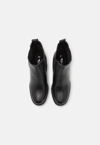 Botines negros de cuero suave, con puntera redondeada, laterales elásticos y tiradores para poner y quitar fácilmente. Talla marcada como 37.