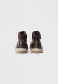 Botas de tobillo de cuero marrón y ante con cuellos acolchados, cremalleras laterales y suela de goma ligera. Presentan detalles de costura en contraste.