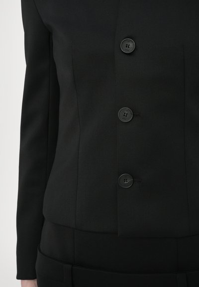 Black tailored blazer featuring a fitted design, soft texture, and three black buttons on the front. Subtle stitching detail near the buttons.