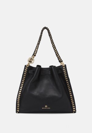 Czarna skórzana torebka Michael Kors z złotym łańcuszkiem i zawieszką z logo, miękko teksturowanym korpusem oraz złotym logo na dole pośrodku.