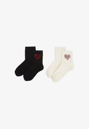 Schwarz-weiße Knöchelsocken aus Baumwollmischung mit einem roten Strassherz-Design. Jedes Paar hat eine glatte Textur und klassische gerippte Bündchen.