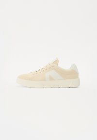 Sneaker in rete beige con accento logo bianco. Punta arrotondata, design con lacci, suola in gomma con texture e colletto imbottito per il comfort.