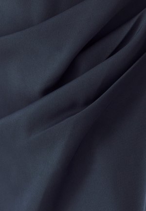 Tmavě námořnická tkanina s hladkým matným povrchem, s jemnými záhyby a sklady, naznačujícími ohebnost a měkkost.