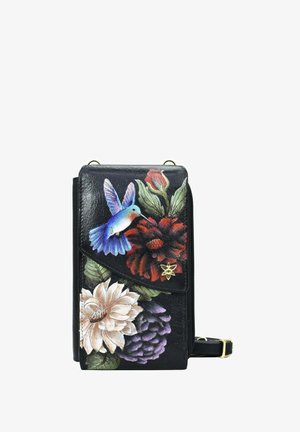 Schwarze Ledertasche mit bunten Blumen- und Kolibri-Motiven. Die Klappe hat eine goldene Akzentuierung. Kompakt, mit einem Reißverschluss und verstellbarem Tragegurt.