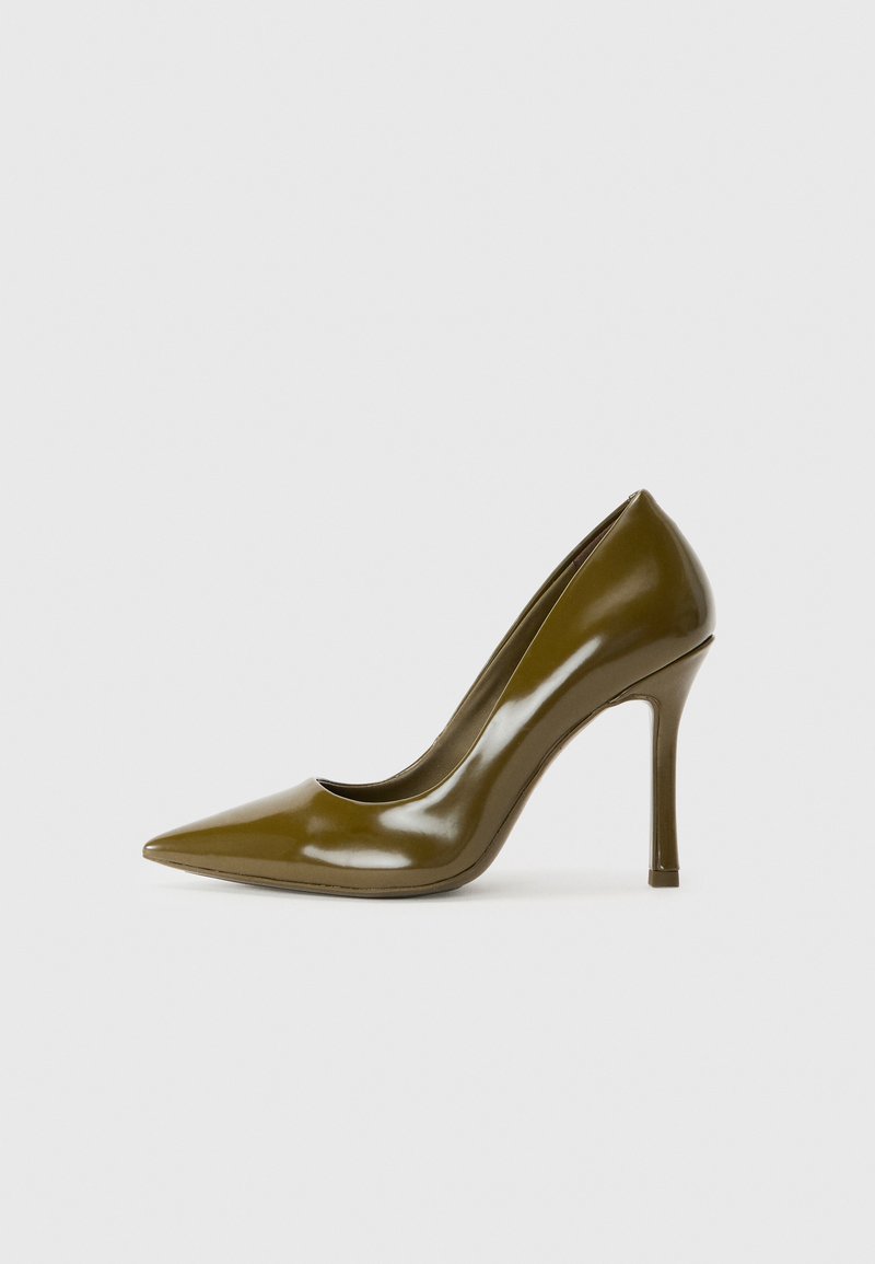 Pompe à talon aiguille en cuir verni vert olive avec un bout pointu, une texture lisse et une silhouette épurée. Talon aiguille de 10 cm.