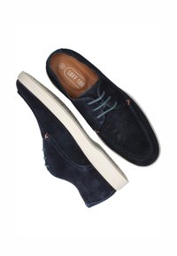 Maritieme suede schoenen met een witte rubberen zool, voorzien van lichtblauwe veters en subtiele oranje stiksels. Rond neus ontwerp.
