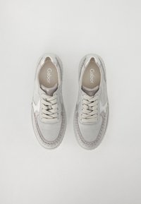 Zapatillas de ante gris claro con un acabado texturizado, detalles en contraste, punta redonda y cordones planos. Presentan costuras decorativas a lo largo de la suela.