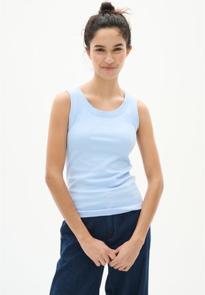 Lichtblauw geribbeld tanktop met een brede halslijn en mouwloos ontwerp, gecombineerd met donkere spijkerbroek.