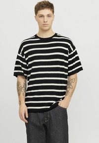 Sort og hvid stribet kortærmet t-shirt med rund hals, lavet af blødt stof, løs pasform, der har tydelige vandrette striber.